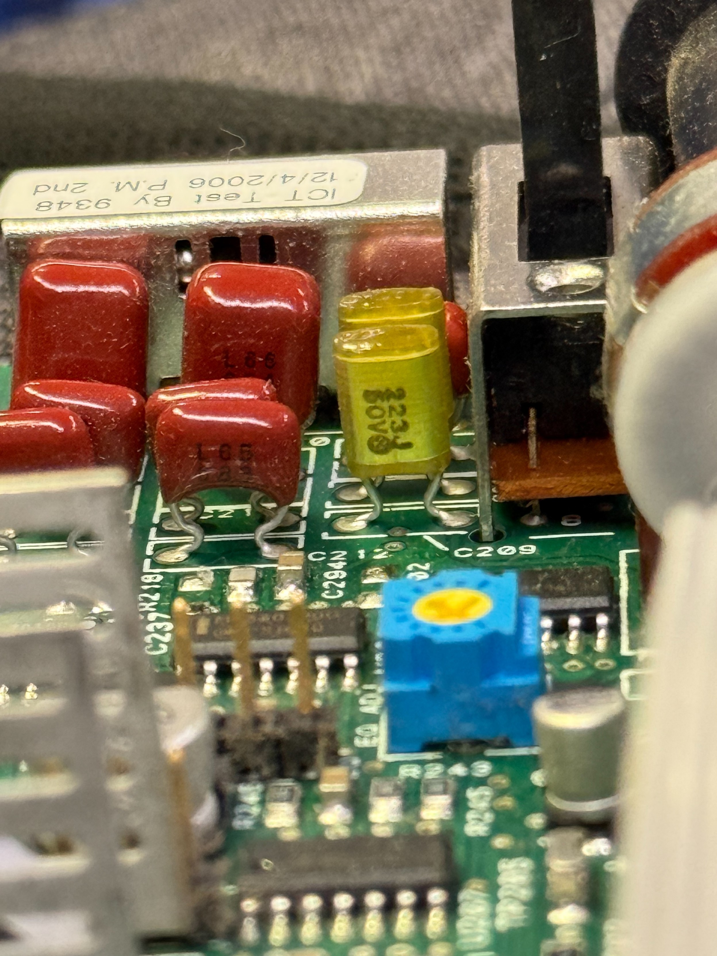 Closeup of cluster of capacitors with some brown film caps and some yellow transparent ish ones, snuggled up beside a switch